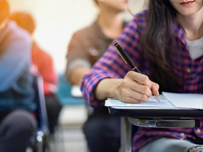 Esame a scuola, primo piano su penna e banco